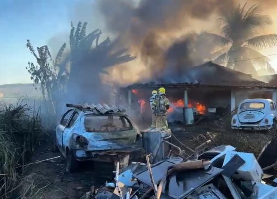 Corpo de Bombeiros combate incêndio em vegetação que se propagou atingindo veículos e outros materiais de residência em Lagarto